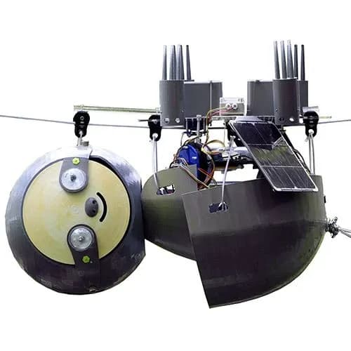 Роботизированный ленивец SlothBot висит вниз головой на тросе. Оснащён солнечной панелью и электроникой.