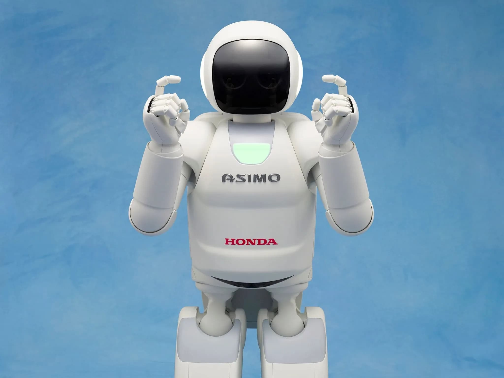 Человекоподобный робот ASIMO поднимает пальцы вверх.