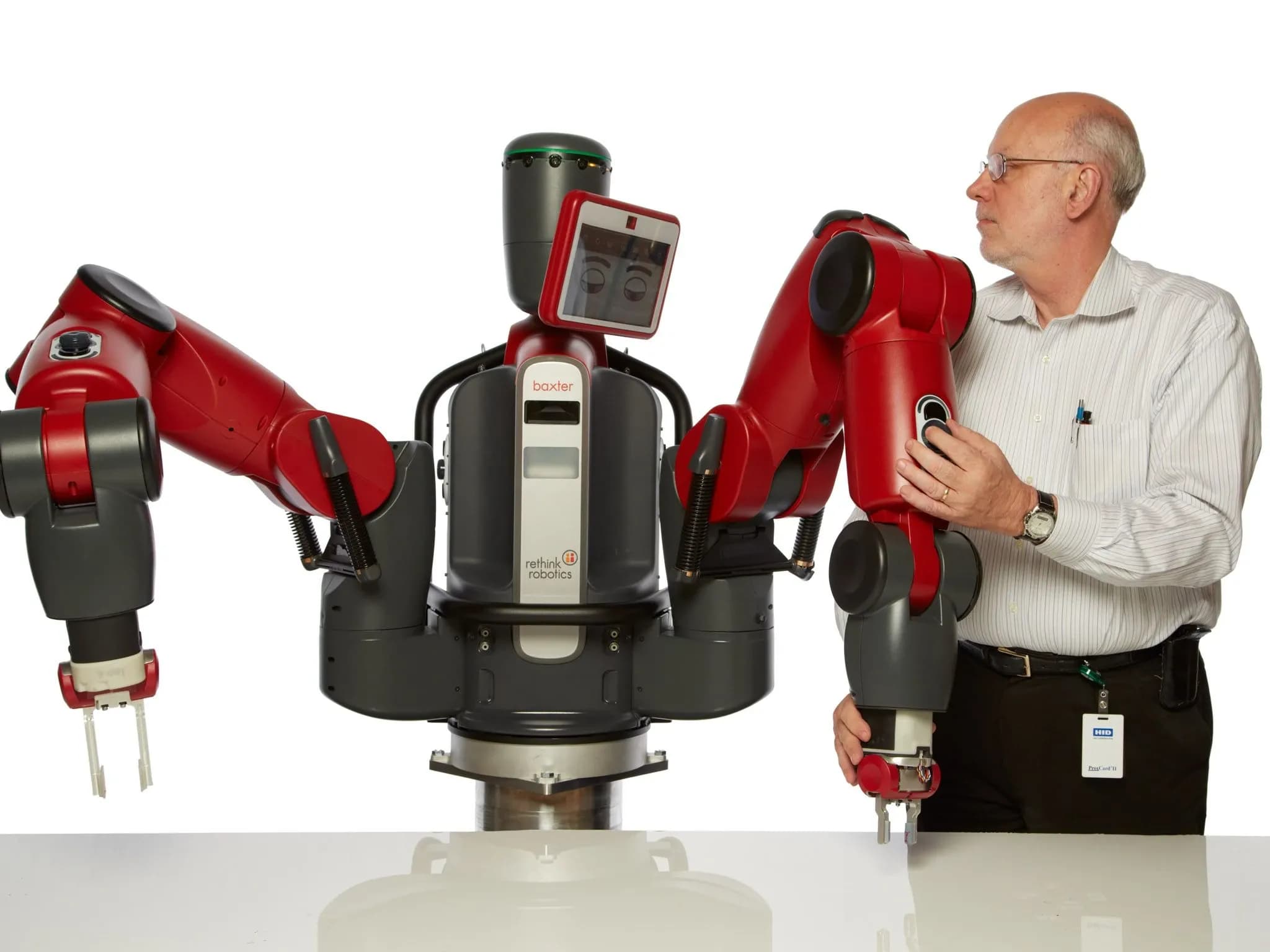 Мужчина держит руку Baxter — промышленного робота.