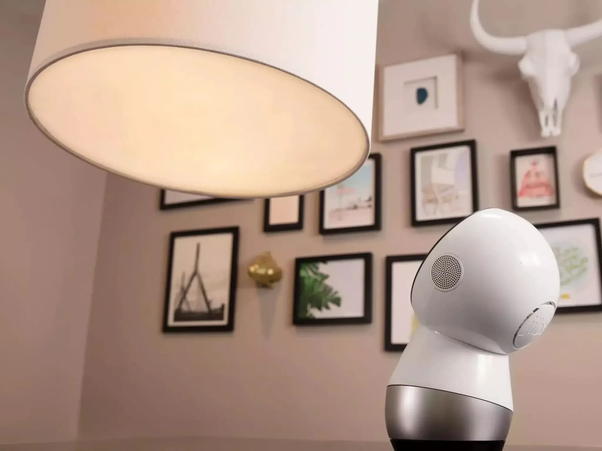 Робот Jibo смотрит вверх на большую лампу.