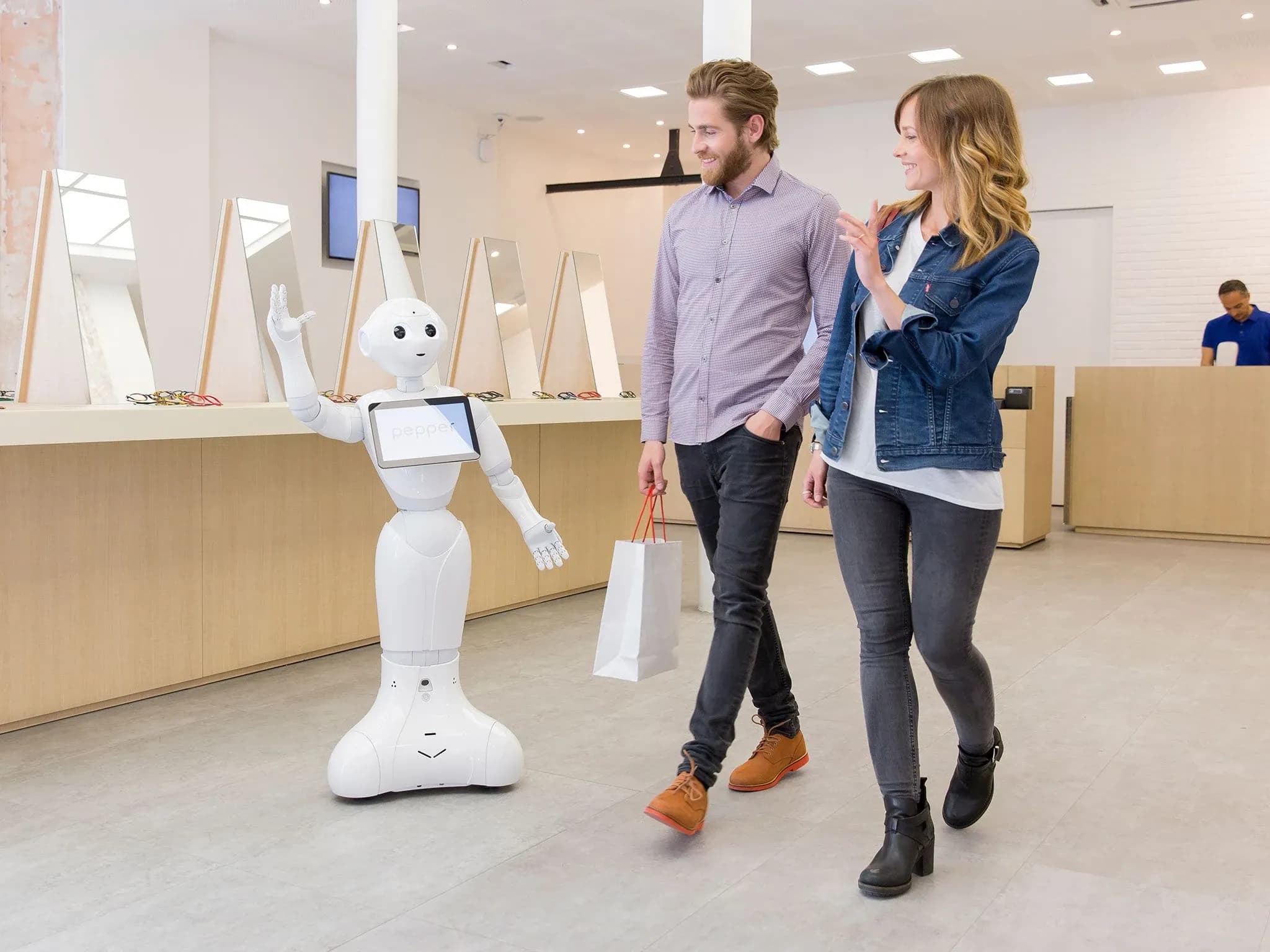 Pepper приветствует клиентов, уходящих из магазина.