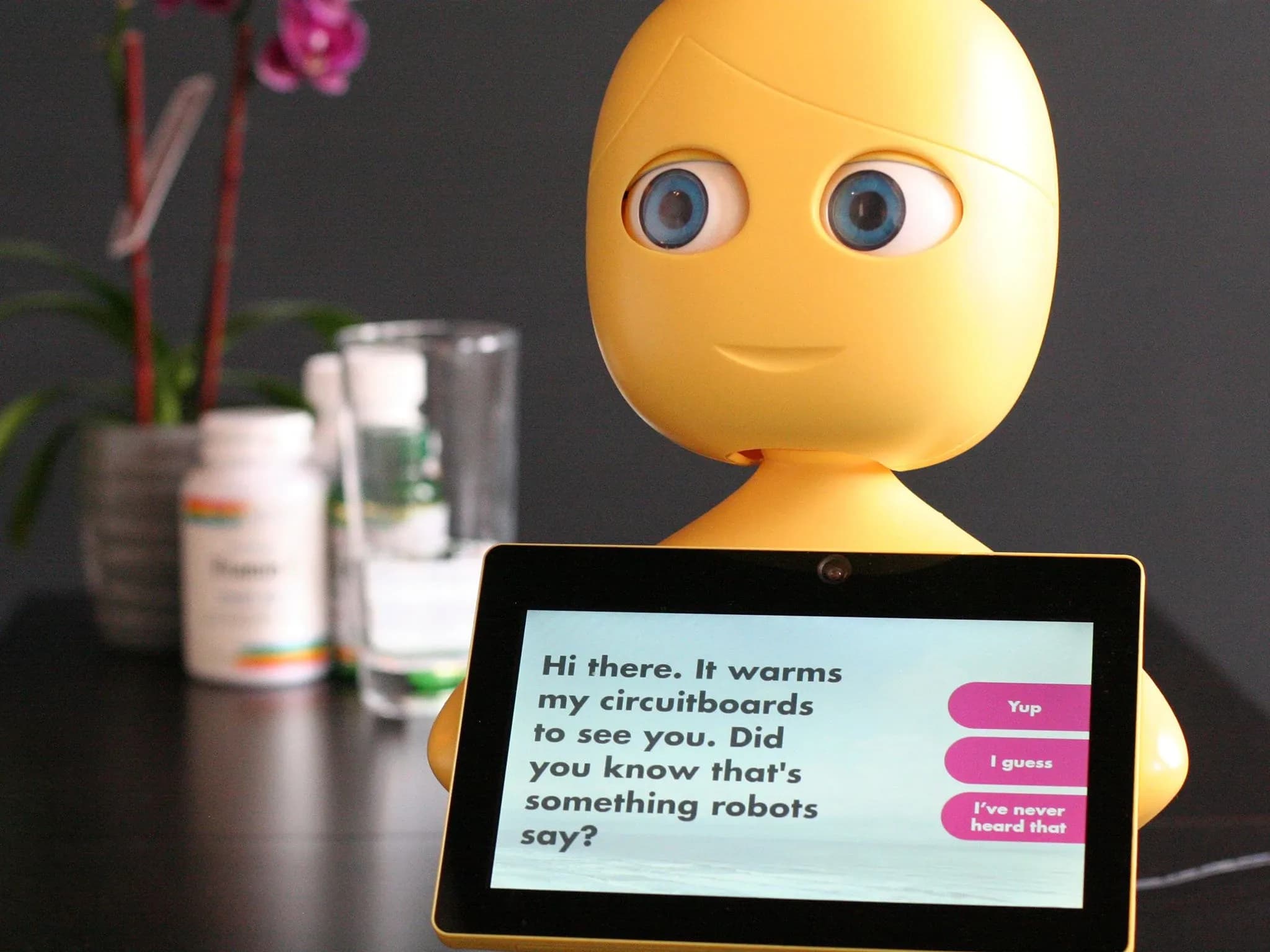 На экране планшета Mabu написано: «Привет. У меня аж платы греются от радости тебя видеть. Знаешь, роботы так говорят?»