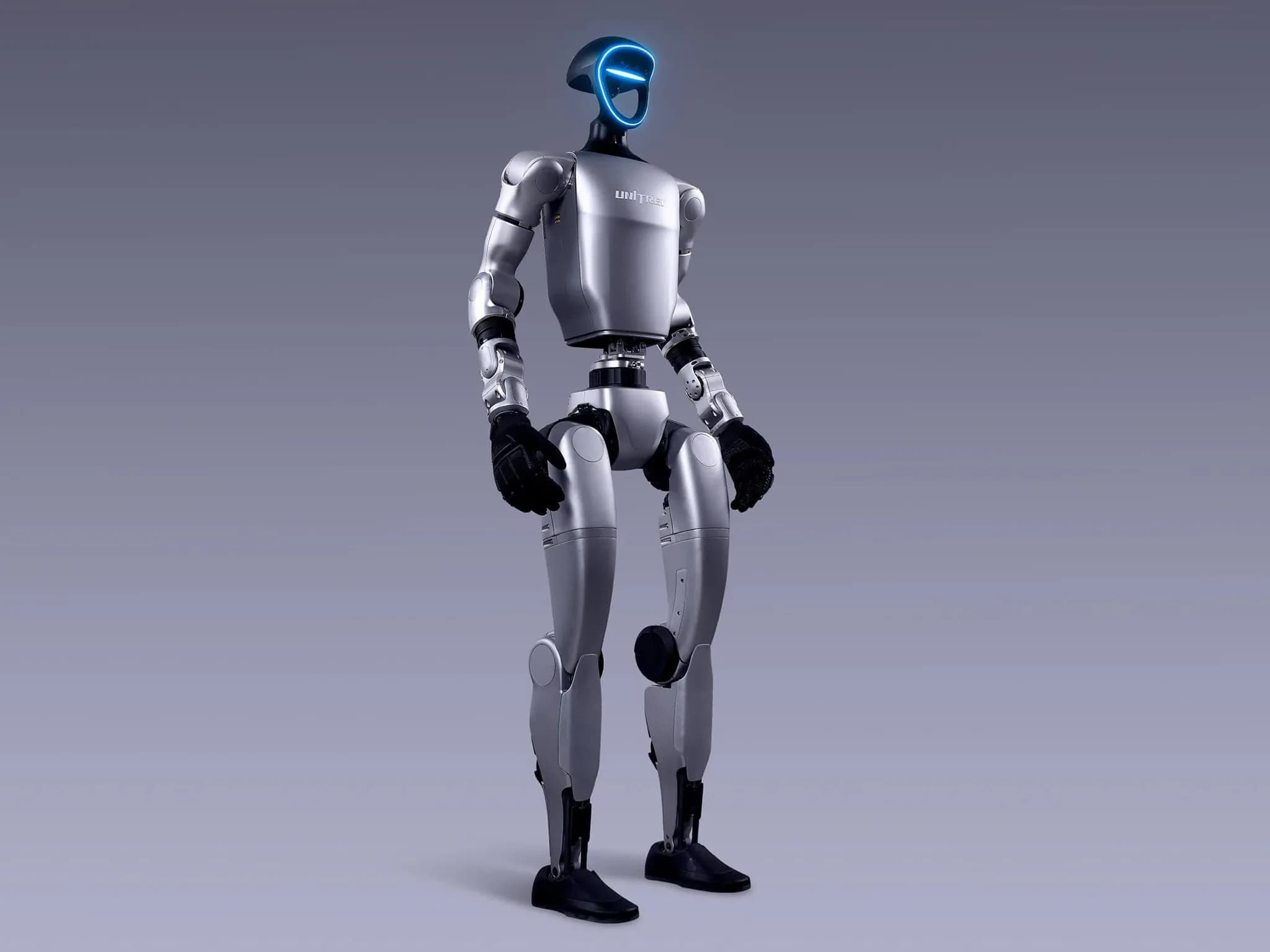 Двуногий гуманоидный робот G1 от Unitree Robotics с двумя руками, оканчивающимися чёрными перчаточными кистями с пятью пальцами. Лицо в форме рамки с синей подсветкой оснащено камерами и датчиками.