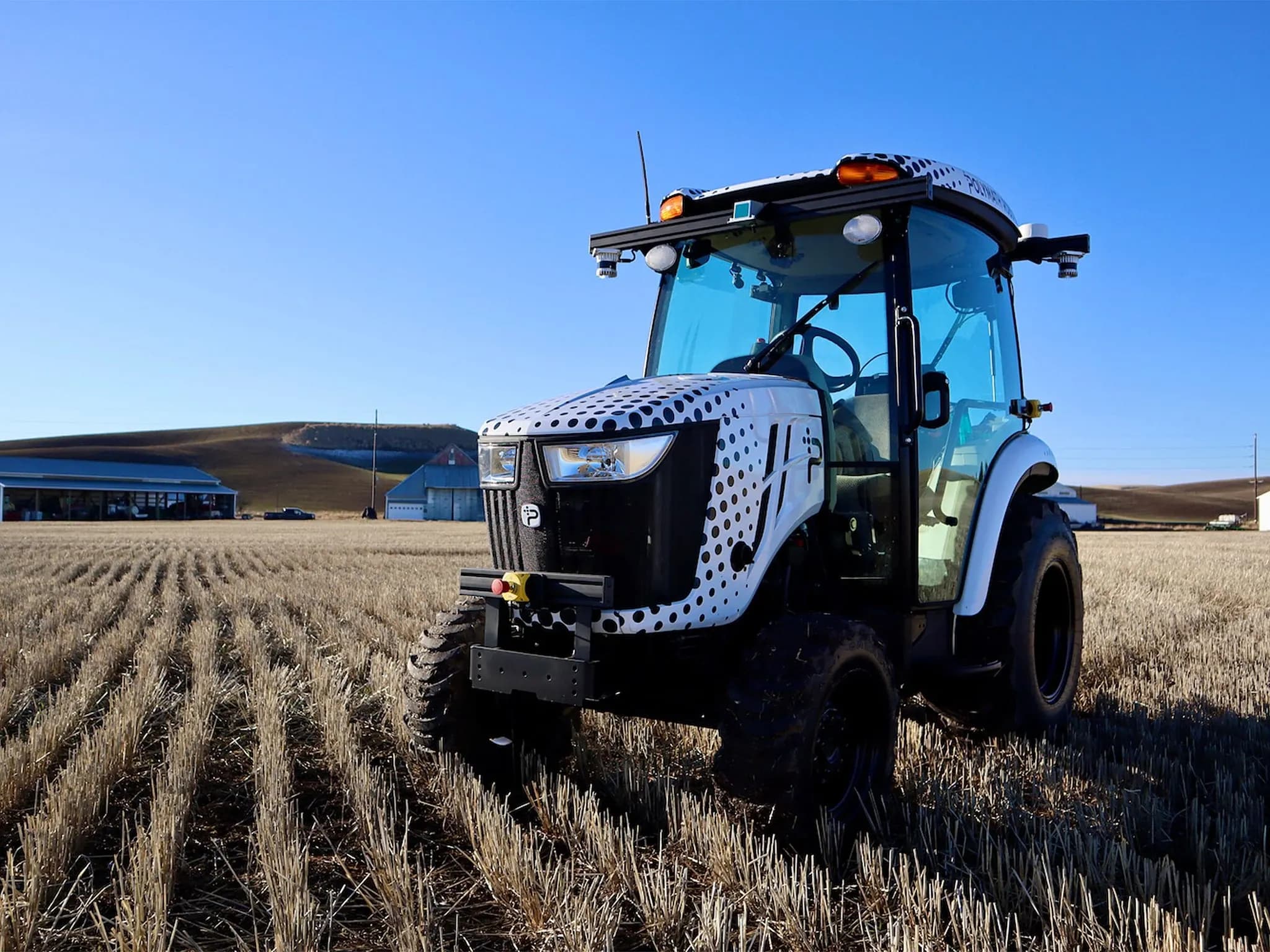 Автономный трактор Polymath Robotics стоит на поле.