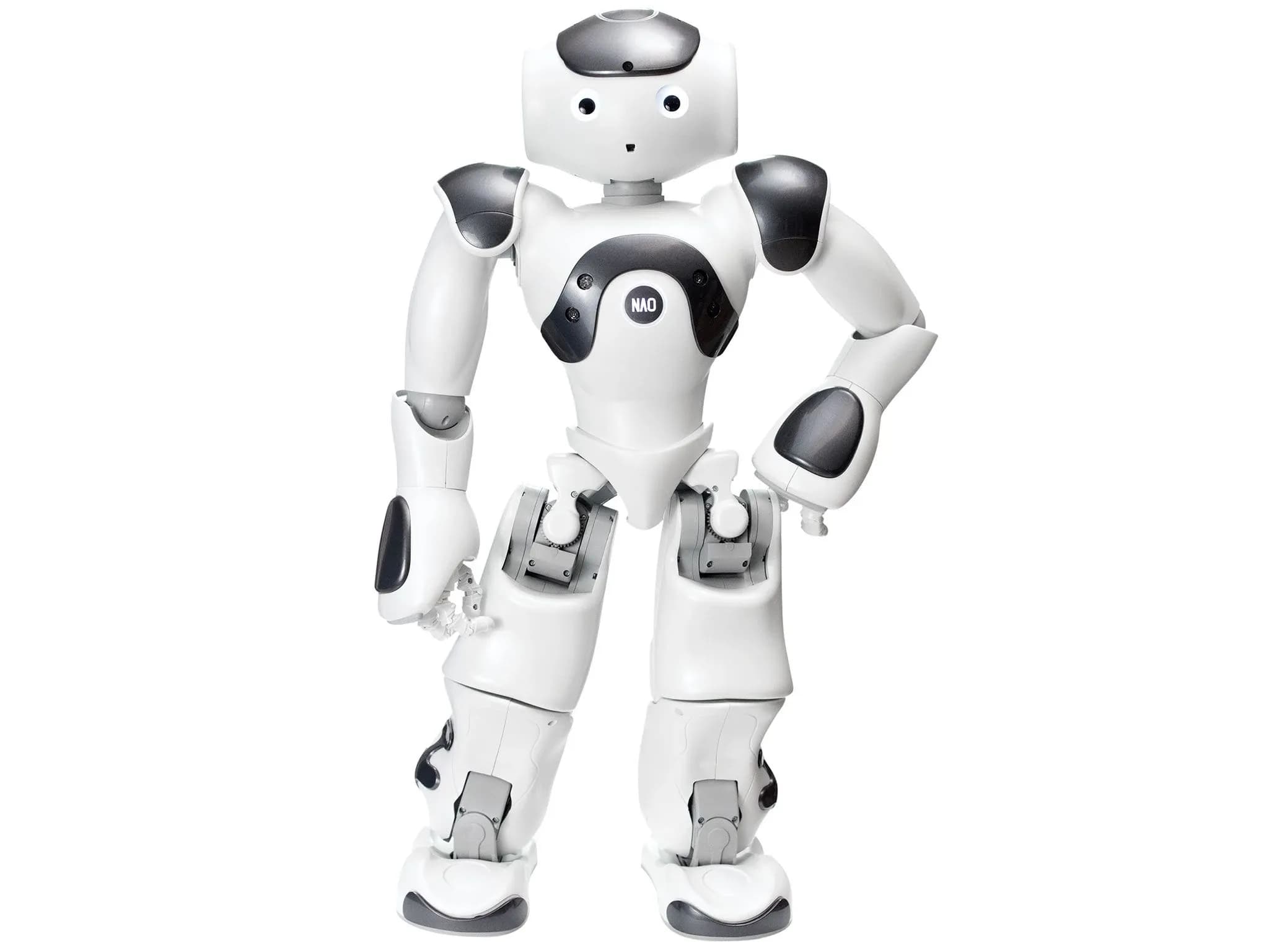 Nao — дружелюбный мультяшный гуманоидный робот бело-серебристого цвета — стоит, подбоченившись. У него два глаза и небольшое отверстие, образующее рот.