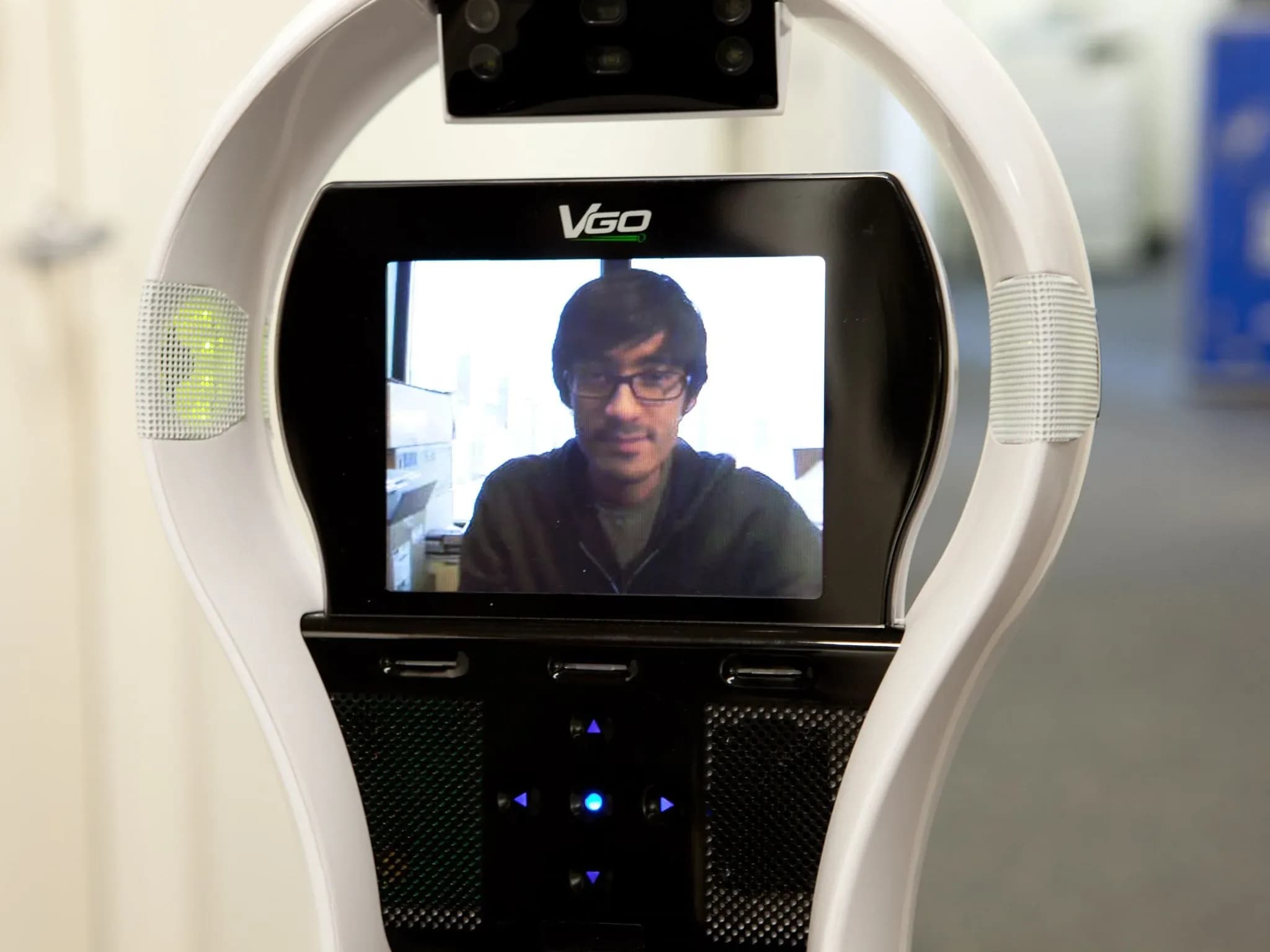 Крупный план экрана VGo — на нём темноволосый мужчина в очках.
